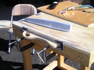 Sanding block clamped to edge of table